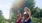 two girls walking in front of a tree